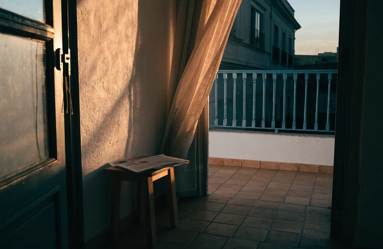 Interior de un piso español al atardecer con luz dorada entrando por la ventana