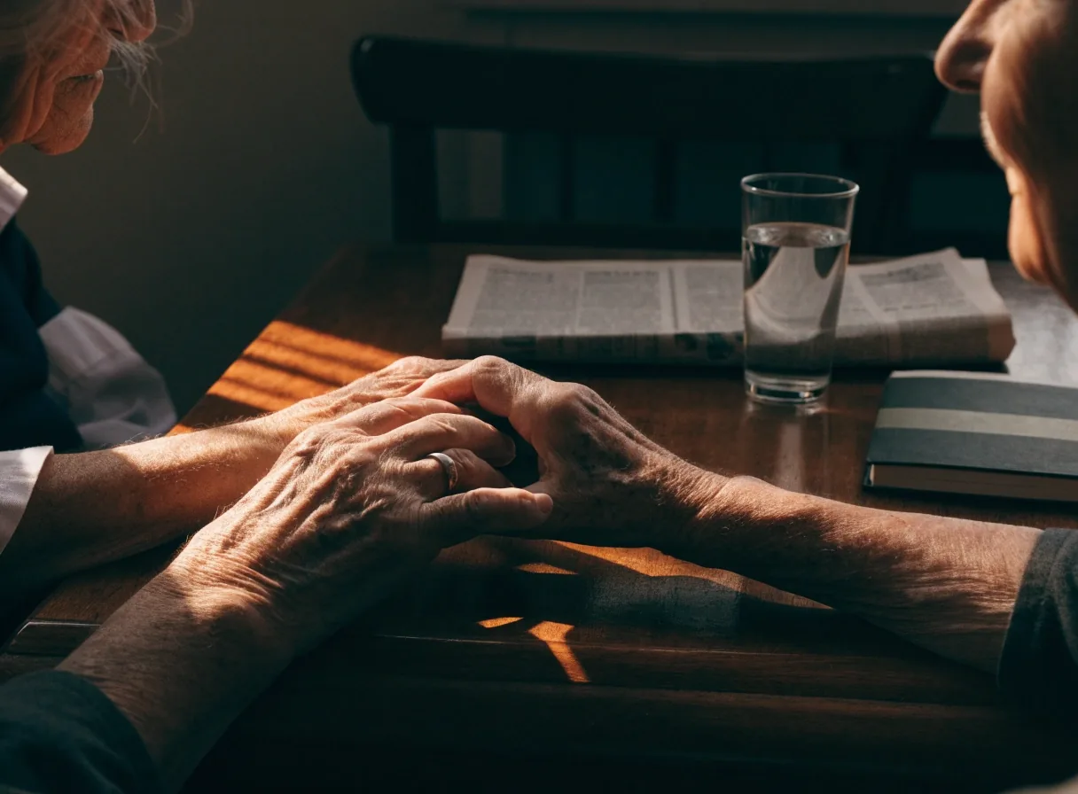 Manos de una pareja sobre la mesa de un comedor español con luz de tarde